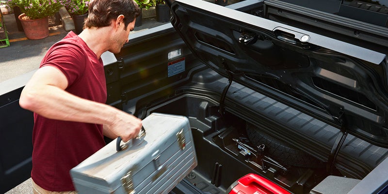 A 2024 Honda Ridgeline owner packing the trunk of his car with tools.