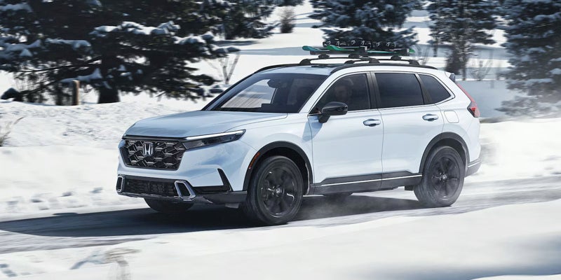 A white 2025 Honda CR-V Hybrid in the snow.