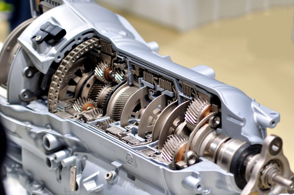 The image shows a close-up of a car's automatic transmission system with its internal gears and components.