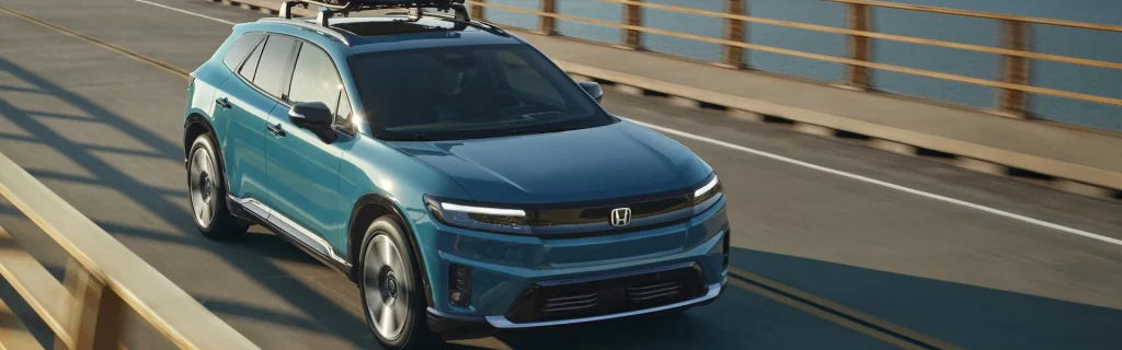 A blue Honda Prologue SUV driving on a bridge.